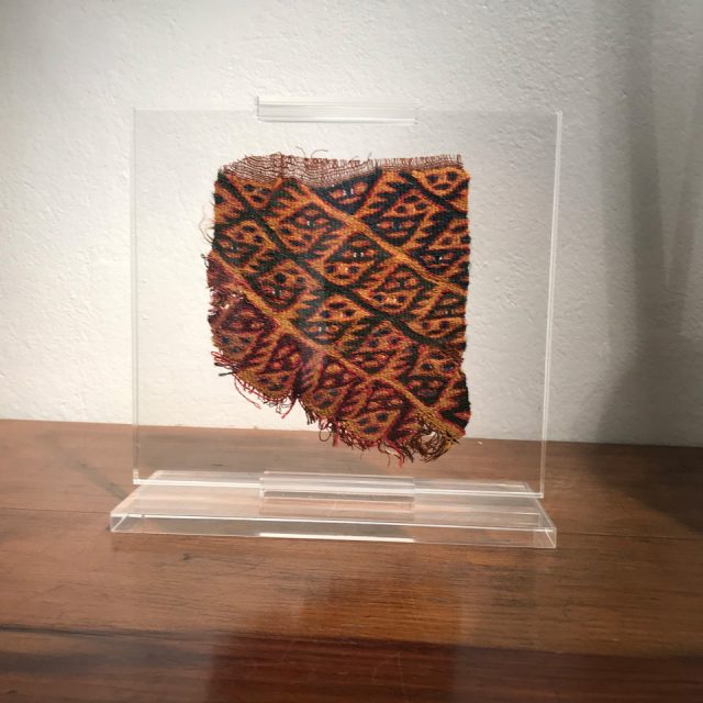 Fragmento de textil antiguo en soporte de acrílico